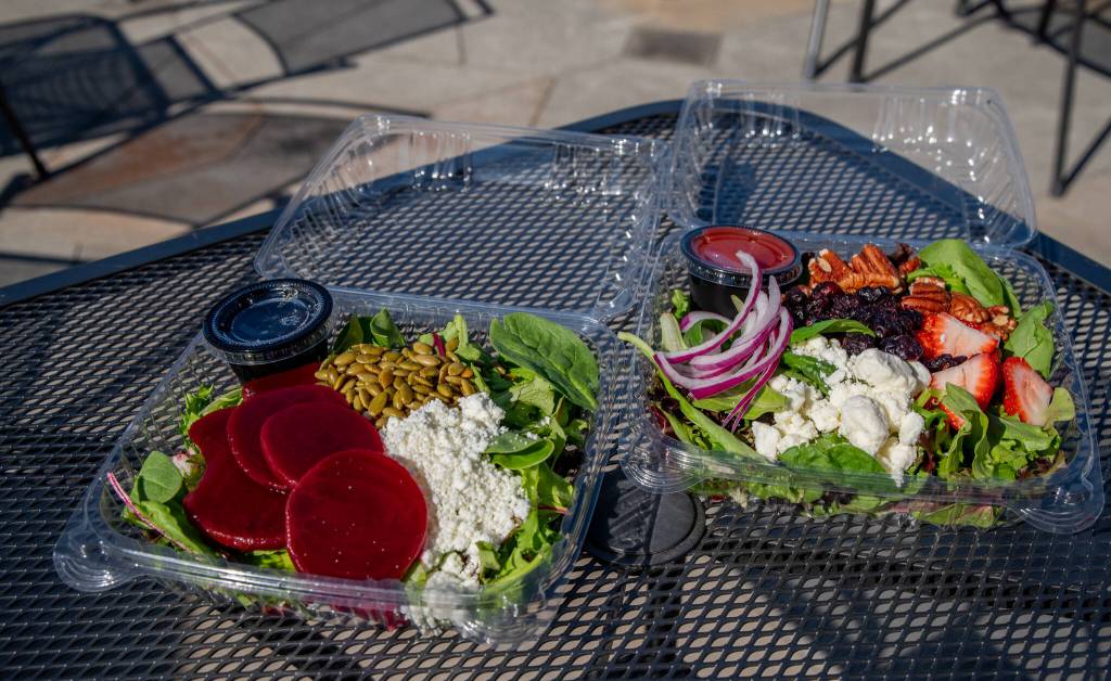 Sequim Gazette photo by Emily Matthiessen / Original Grinds Coffee Co. offers freshly prepared salads on-the-go or at their outdoor seating area. On the left is the pickled beet salad with goat cheese and pepitas, and on the right is the berry nut salad with strawberries, craisins, pecans, feta and red onions. Owner Lindsey Forshaw said she wants to offer food that is healthy as well as fast.