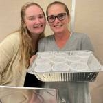 Sequim Gazette photo by Matthew Nash/ Daughter and mother team Olivia and Heather Owen with Belles Black Pot ready some free pulled pork macaroni and cheese samples during the Business Showcase. Heather said macaroni and cheese is one of the daily staples at their River Road coffee shop and barbecue restaurant and pulled pork, brisket, chicken and pastrami are smoked in-house by her husband Anthony. Barbecue and cheese sauces are also made from scratch, she said.