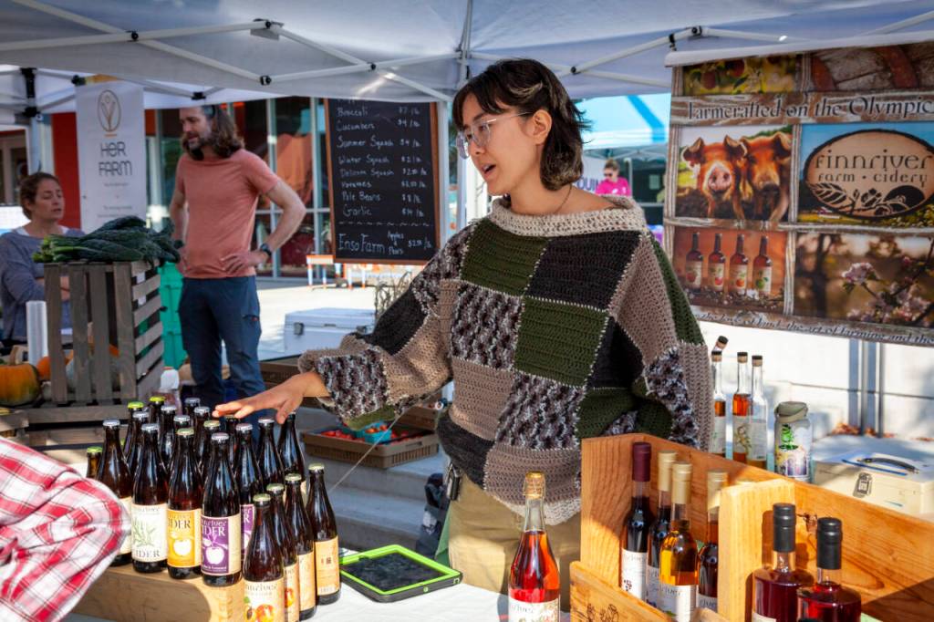 Photo by Amy Nash for Eat Local First Olympic Peninsula and NODC/WSU Clallam Extension / Staff at the Finnriver Farm & Cidery booth at the Sequim Farmers & Artisans Market greet visitors.