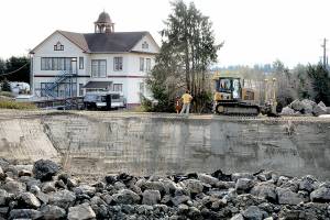 A bulldozer levels dirt along a new levee being built along the Dungeness River on Saturday not far from the mouth of the river near the Dungeness community north of Sequim. The first phase of the multi-year levee setback project includes construction of a new levee and an embankment to realign Towne Road, as well as culverts and restoration of the river's floodplain. In the background is the historic Dungeness Old Schoolhouse. (Keith Thorpe/Peninsula Daily News)