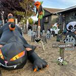 Sequim Gazette photo by Matthew Nash/ On one side of the front yard everything from inflatables to gravestones to skeletons fill space, while on the other side, inflatables and giant cobwebs greet visitors