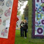 Sequim Gazette photo by Matthew Nash/ Carolyn and Alan Jones of Diamond Point visit the Sunbonnet Sue Quilt Clubs outside show on July 16 in Pioneer Memorial Park. We came every year (before COVID-19) and I love (the park). I love the openness, Carolyn said.