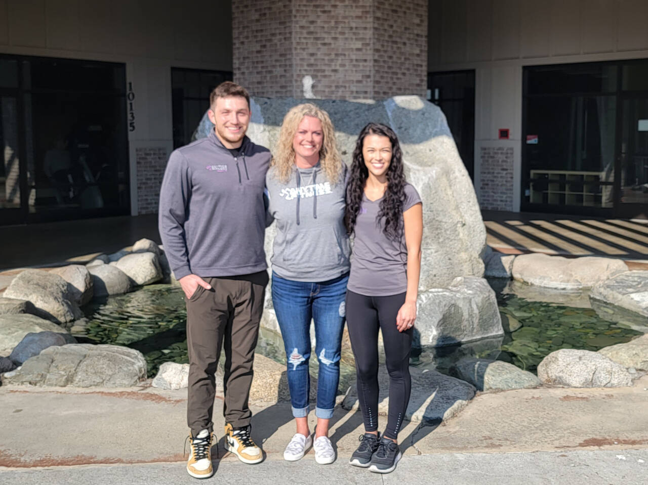 Submitted photo / New Anytime Fitness owners Evan Hurn and Makayla Payne (right) stand with former co-owner Erin Green standout side the business at Rock Plaza earlier this year. Hurn and Payne transitioned from employees to owners this fall.