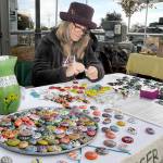 Keith Thorpe/Peninsula Daily News
Sharon Prosser of Sequim creates refrigerator magnets with hand-painted rocks as part of the Ladybug Project, a fund-raising effort for the Olympic Peninsula Humane Society. Prosser was making and selling magnets for $1 each and taking monetary donations to the society on Saturday at the Port Angeles Farmers Market.