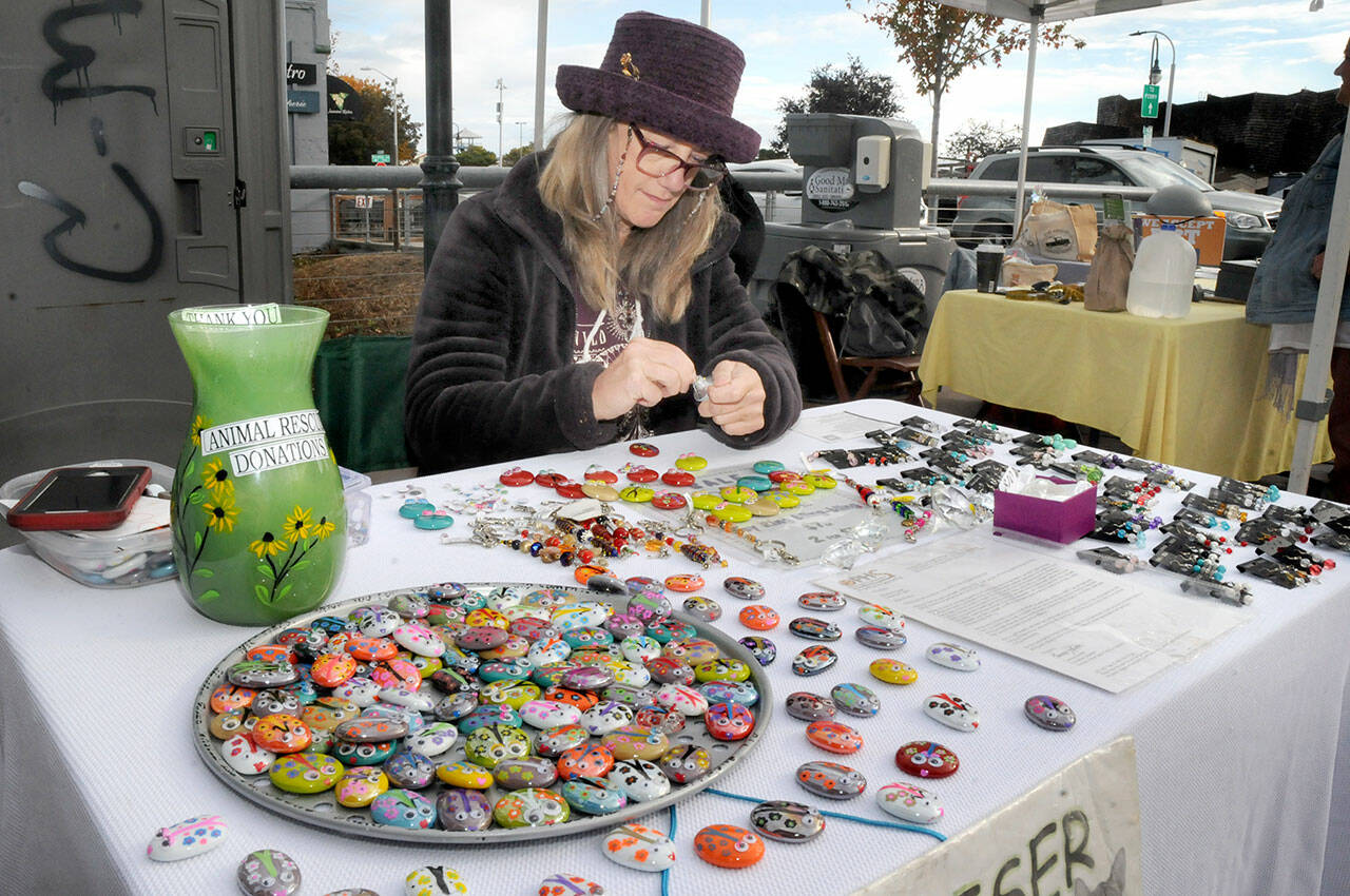 PHOTO BY Keith Thorpe/Olympic Peninsula News Group
Sharon Prosser of Sequim creates refrigerator magnets with hand-painted rocks as part of the Ladybug Project, a fund-raising effort for the Olympic Peninsula Humane Society. Prosser was making and selling magnets for $1 each and taking monetary donations to the society on Oct. 22 at the Port Angeles Farmers Market.