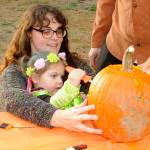 Sequim Gazette photo by Matthew Nash/ Two-and-a-half-year old Poppy Springer carves a pumpkin dressed as a fairy with help from mom Sierra Perdue during the Sequim Prairie Granges Trunk-or-Treat.