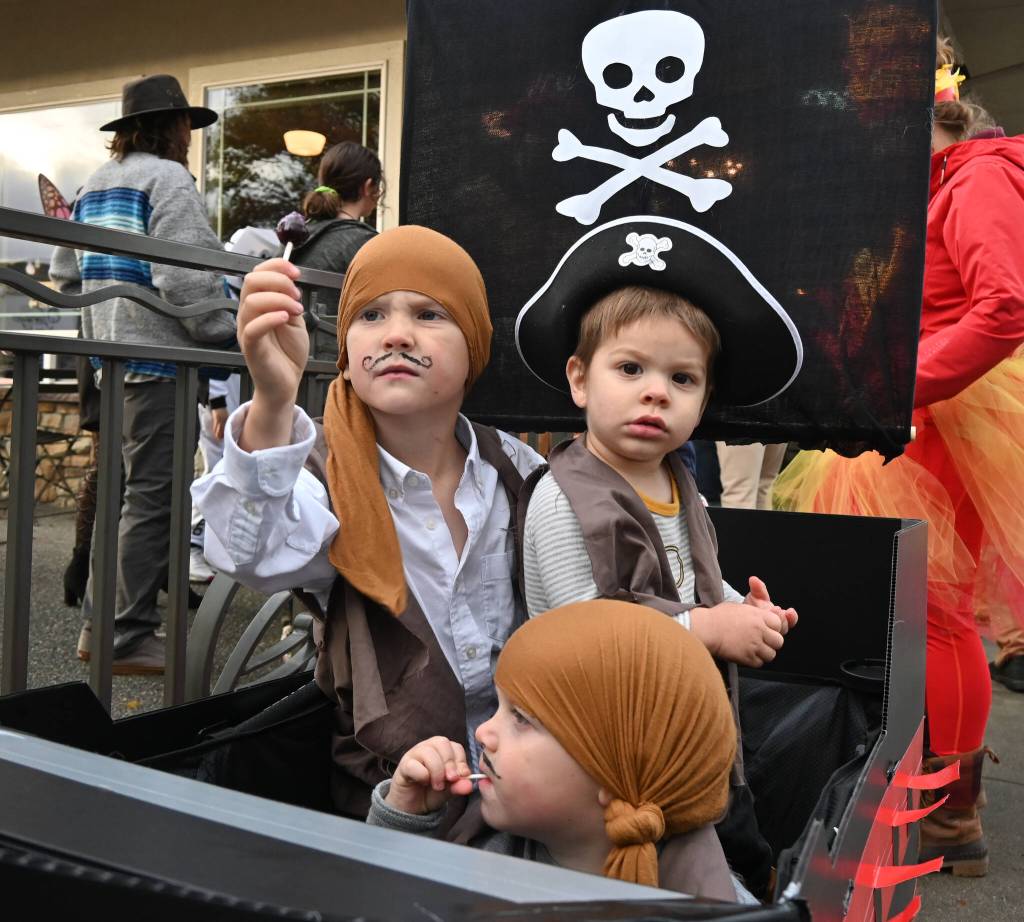 Sequim Gazette photo by Michael Dashiell / Young pirates  from left, Easton Hightower, Lincoln Davila, and (in front) Caron Hightower  sail their wagon ship toward some tasty candy treats at the downtown Sequim Halloween event hosted by local businesses and the Sequim-Dungeness Valley Chamber of Commerce.