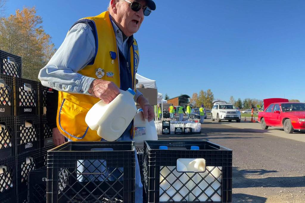 Sequim Gazette photo by Matthew Nash/ Pat Phillips, past zone chairman with the Sequim Valley Lions, grabs some meal bags to place in a trunk on Nov. 18 during the Family Holiday Food Bag Distribution event.