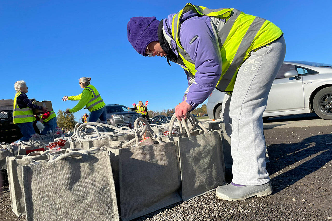 Sequim Gazette photo by Matthew Nash
Megan Caldwell returns to Carrie Blake Community Park to work with her dad Bert to help place meal bags in vehicles on Nov. 18 during the Family Holiday Food Bag Distribution Day.