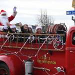 Sequim Gazette photo by Michael Dashiell / Santa Claus rides into downtown Sequim in a vintage fire engine as part of Saturdays Hometown Holidays event, accompanied by Sequim Irrigation Festival royalty: from left, princess Lauren Willis, queen Isabella Williams, and princesses Katherine Gould and Ellie Turner.