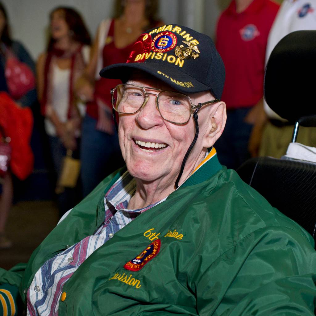 PHOTO BY Emily Matthiessen 
Patricia Robison makes a wish on a dandelion. Sequim recently formed a chapter of the nonprofit Twilight Wish, an organization dedicated to granting the wishes of senior citizens.
Photo courtesy of Twilight Wish / Jim Hall had his wish to attend one more reunion of the Sixth Marine Division granted in 2012. Mary E. Farrell, director of community relations at the Twilight Wish Foundation said, At the time of his wish granting, he was 85 and disabled. We met Jim several times before we granted his wish and he was just the sweetest man, who was so emotional and touched by having his wish granted. Jim was only 16 when the Japanese bombed Pearl Harbor so he lied about his age and enlisted. His division landed on Okinawa in April of 1945 and during an attack by Japanese snipers, Jim was shot twice in the lower abdomen leaving him temporarily paralyzed in the legs. Despite his injuries, he managed to crawl to another critically injured Marine and treated him, but the injured Marine died in his arms. For his bravery, Jim received the Purple Heart and Bronze Star.
