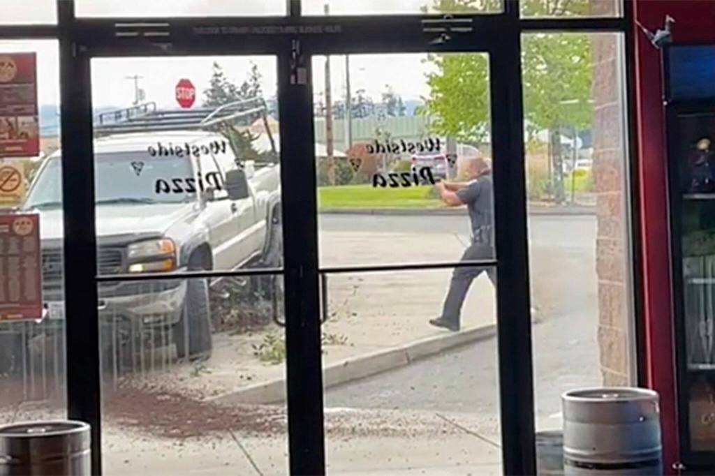 Photo courtesy of Holly Shimer/ Sequim Police Officer Andrew Wagner attempts to stop David Brown, 32, of Tacoma on May 5 outside Westside Pizza before he sped off. Brown allegedly stole the truck and eluded police throughout the city.