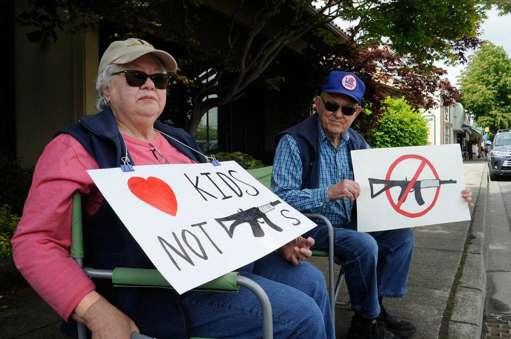 Sequim Gazette photo by Matthew Nash/ Jan and Eldon Dennis of Sequim sat on June 11 along Washington Street for the 2022 March for Our Lives with signs theyve kept since the 2018 shooting at Marjory Stoneman Douglas High School in Parkland, Fla. Were not anti-gun. We want to let our community know how we feel, especially about assault guns. We would like them banned, said Jan, a retired nurse from Juneau, Alaska. Were anti-easy accessibility, said Eldon, a retired chemistry and physics teacher. The event brought about 200 protesters to downtown Sequim.