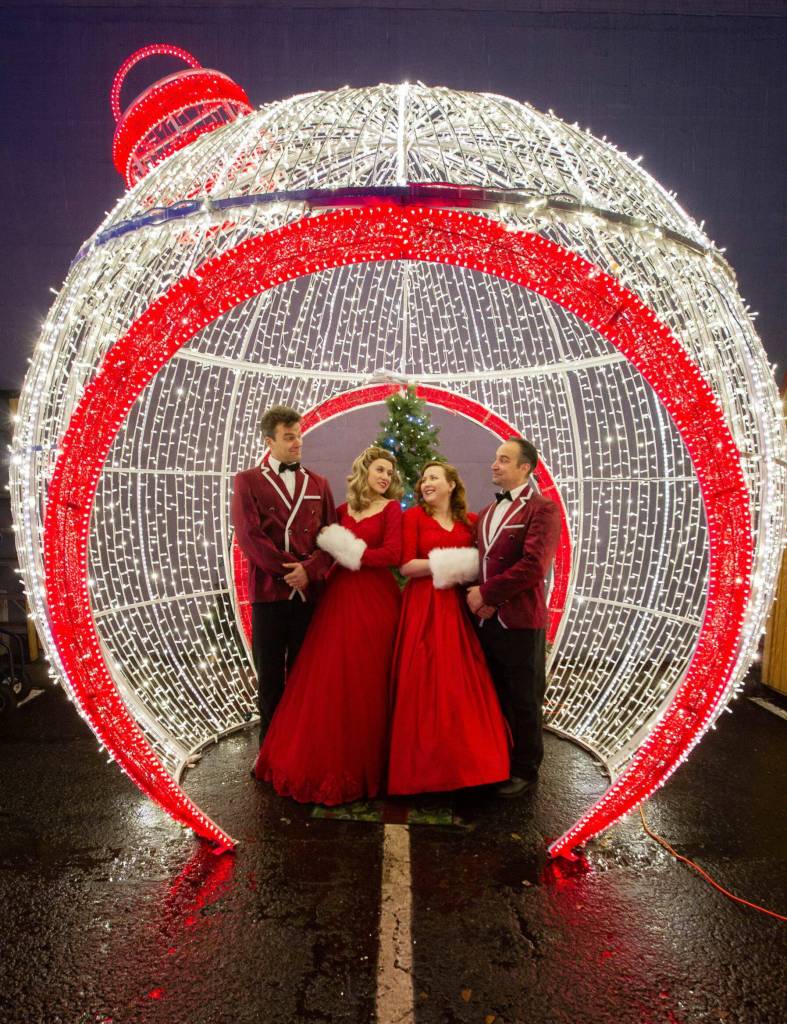 Photo by Bob Spink, courtesy of Ghostlight Productions / Noah Long (Phil Davis), Anna Pederson (Judy Haynes), Cecie McClelland (Betty Haynes) and Jeremy Pederson (Bob Wallace) pose in their costumes for "White Christmas" at the PA Winter Ice Village.