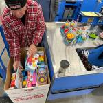 Sequim Gazette photo by Matthew Nash/ In his first year volunteering, Gary Dills of Sequim helps pack a Toys for Tots box on Dec. 1. Its a great thing to do at Christmas time, he said. It keeps me busy and its hard work but fun.