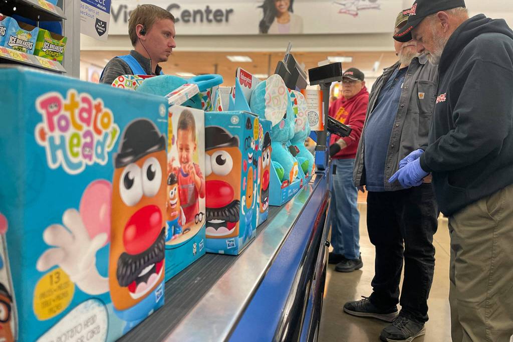 Sequim Gazette photos by Matthew Nash
Cody Avila with Walmart helps ring up Mr. Potato Heads, plush elephants and about 600 other toys for Toys for Tots volunteers Guy Iredale, Ron Zimmermann and Eric Miner.