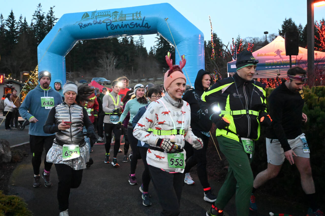Sequim Gazette photo by Michael Dashiell / Runners and walkers cross the starting line at the 2022 Jamestown SKlallam Tribe 5k/10k race on Dec. 3. Many participants, including Timea Tihanyi of Seattle (553), wore holiday-themed costumes and flair.