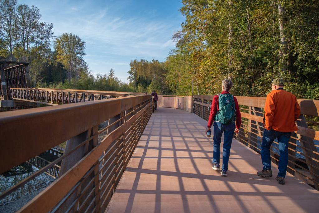 Sequim Gazette photo by Emily Matthiessen/ Pedestrians and bicyclists in early October check out the newly-reopened bridge at Railroad Bridge Park, part of the Olympic Discovery Trail.