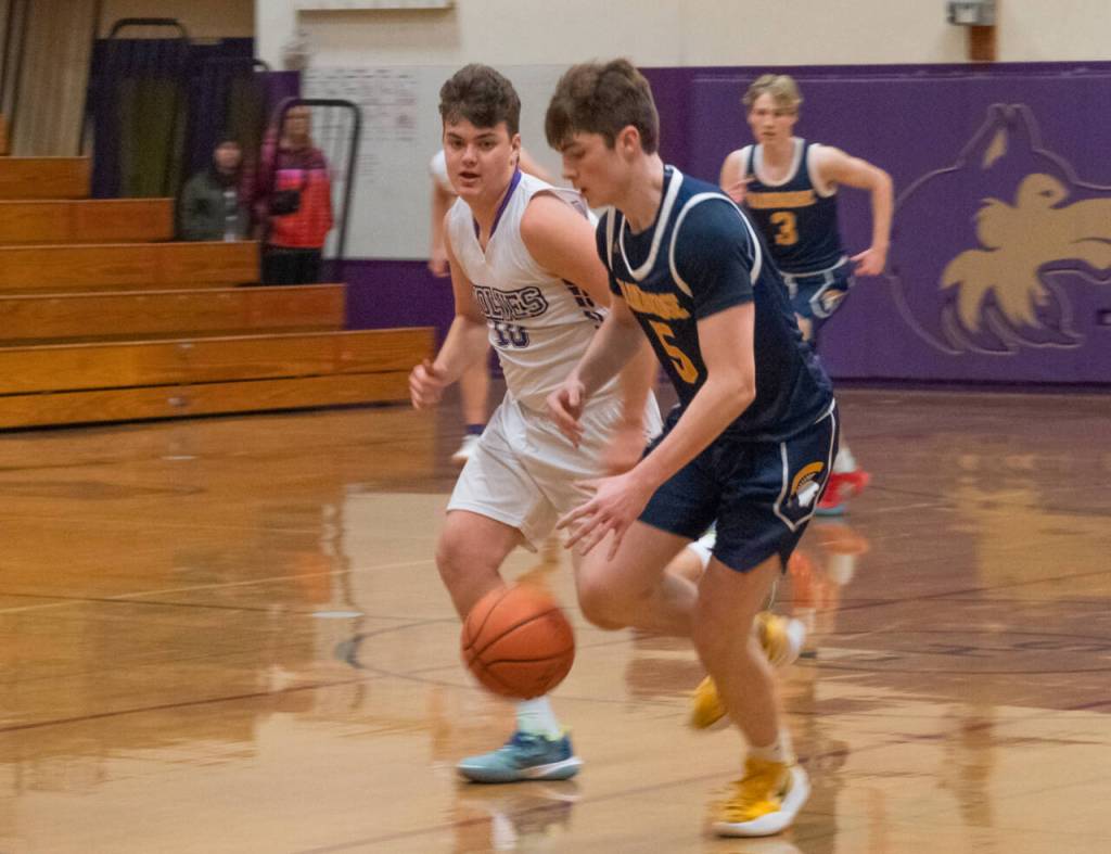 Sequim Gazette photo by Emily Matthiessen Sequims Keenan Green, left, pursues Bainbridges Noah Davis in the Sequims Olympic League home game against the 3A Spartans on Dec. 6.