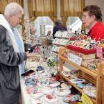 Photo by Keith Thorpe/Olympic Peninsula News Group
Sandie Kiehl of Sequim, left, makes a purchase from Pat Snyder of Sequim-based China Cat Creations during the Homemade Christmas Craft Fair at the Sequim Prairie Grange near Carlsborg on Dec. 3. The event featured dozens of vendors with a wide variety of holiday gifts and gift ideas created by local artisans.