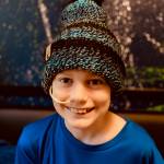 Photo courtesy of Becca Pace / Ten-year-old Carter Pace smiles under one of Becca Paces knitted beanies which are available for sale at etsy.com/shop/HugYourHead and the Southern Nibble food truck. Proceeds from sales are used for supplies for Pace to knit beanies for free distribution at Seattles Childrens Hospital, where Carter is being treated for medulloblastoma, a brain cancer.