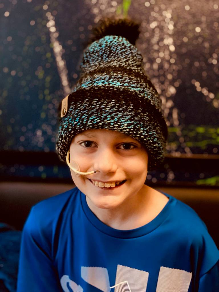 Photo courtesy of Becca Pace / Ten-year-old Carter Pace smiles under one of Becca Paces knitted beanies which are available for sale at etsy.com/shop/HugYourHead and the Southern Nibble food truck. Proceeds from sales are used for supplies for Pace to knit beanies for free distribution at Seattles Childrens Hospital, where Carter is being treated for medulloblastoma, a brain cancer.