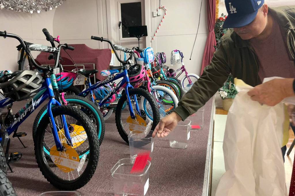 Sequim Gazette photo by Matthew Nash/ Keith Brown of Sequim puts a raffle ticket in a bin for a parent during Toys for Sequim Kids. On why he continues to volunteer: I just enjoy seeing the looks on peoples faces, he said. It (feels good) knowing were giving back.