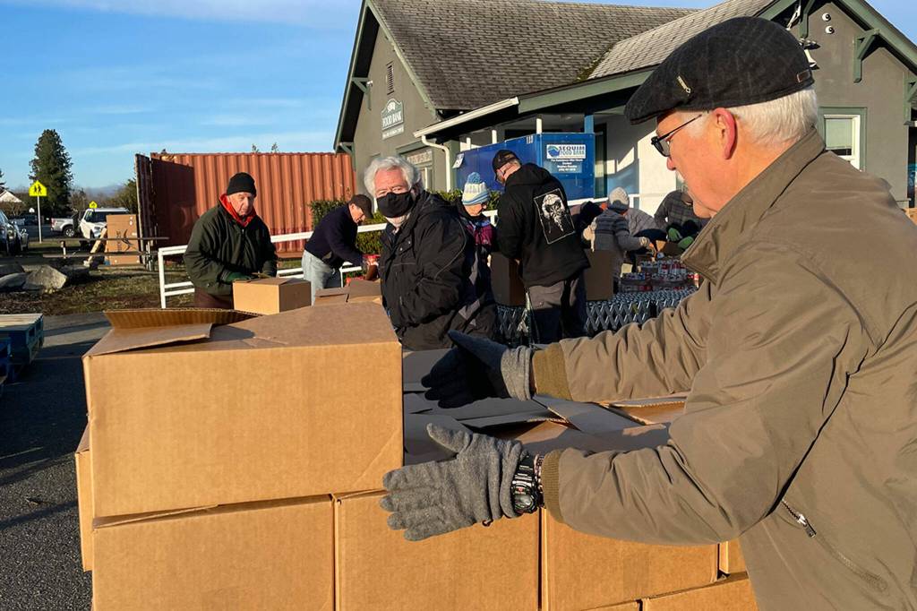 Sequim Gazette photo by Matthew Nash/ Volunteer James Whitney stacks finished meal boxes at Sequim Food Bank for the Family Holiday Food Bag Distribution event on Dec. 16 in Carrie Blake Community Park.