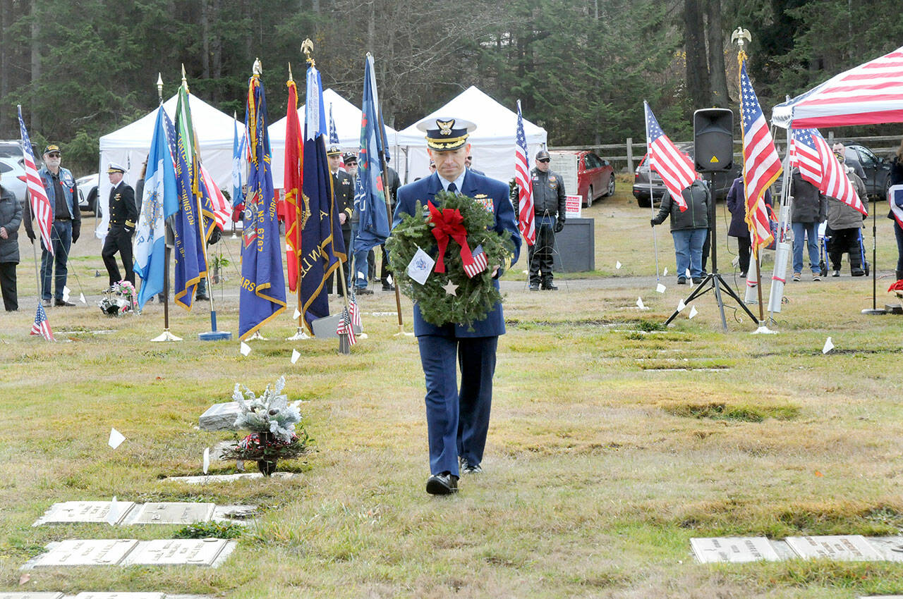 Keith Thorpe/Olympic Peninsula News Group
Cmdr. Brian Tesson, commanding officer of the U.S. Coast Guard Cutter Active, carries a wreath for the grave of Coast Guard veteran Harold Hanusa, who served during World War II, during the Wreaths Across America ceremony at Mount Angeles Memorial Park in Port Angeles on Dec. 17. The event, part of a national initiative to honor veterans of military service, saw individual branches of the military recognized during the ceremony followed by the placement of more than 2,300 wreaths for servicemen and women at six cemeteries across the North Olympic Peninsula.