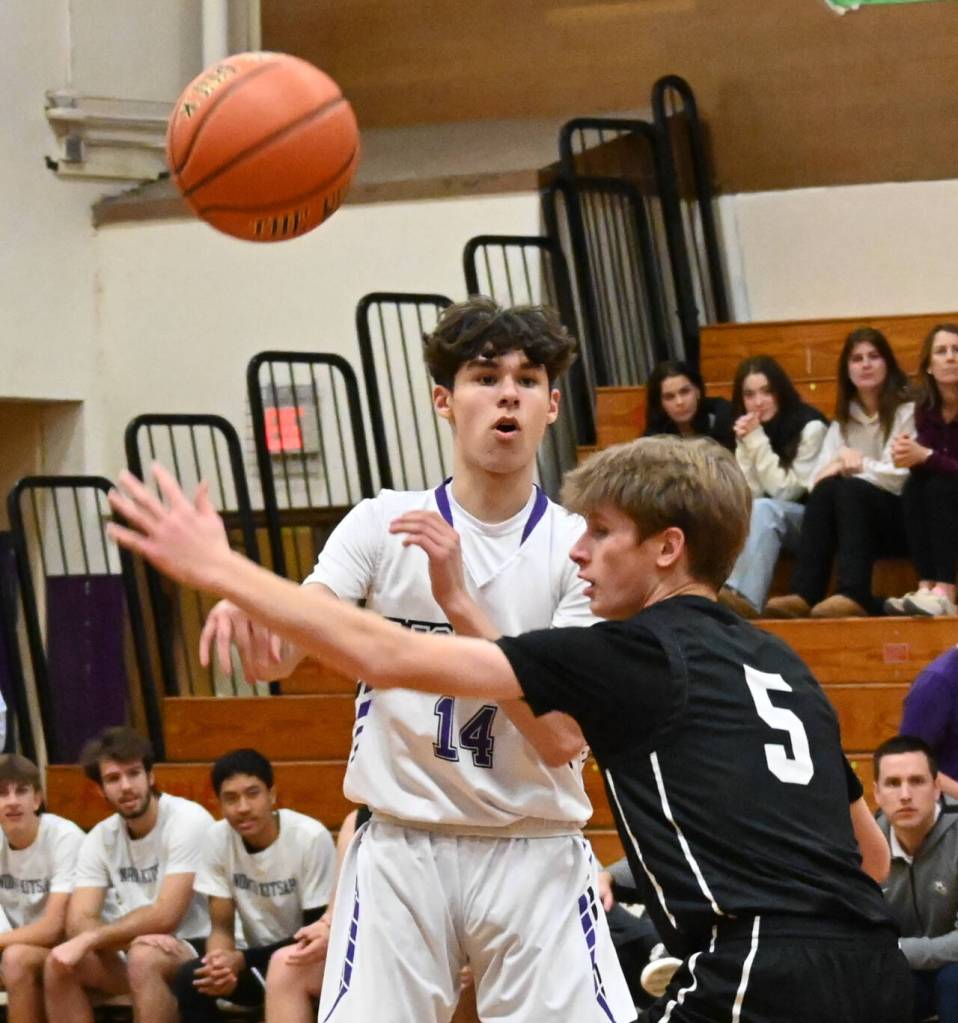 Sequim Gazette photo by Michael Dashiell / Sequims Vincent Carrizosa, left, slips a pass to a teammate as North Kitsap guard Ethan Gillespie defends, in a Dec. 19 Olympic League match-up.