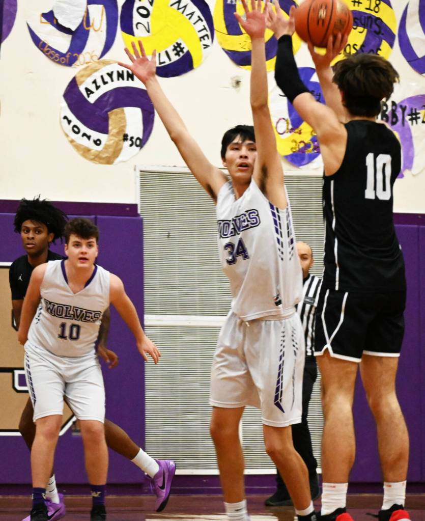 Sequim Gazette photo by Michael Dashiell / Sequims Isaiah Moore (34) and Keena Green (10) look on as North Kitsaps Cade Orness puts up a jumpshot in the Vikings 82-60 win at Sequim on Dec. 19.