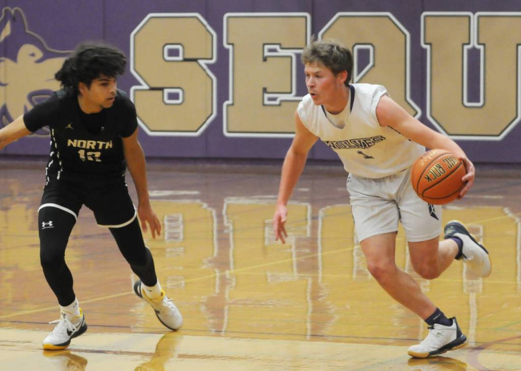 Sequim Gazette photo by Michael Dashiell / Sequim guard Zackary Thompson, right, looks to drive past Harry Davies of North Kitsap in a Dec. 19 Olympic league match-up in Sequim.