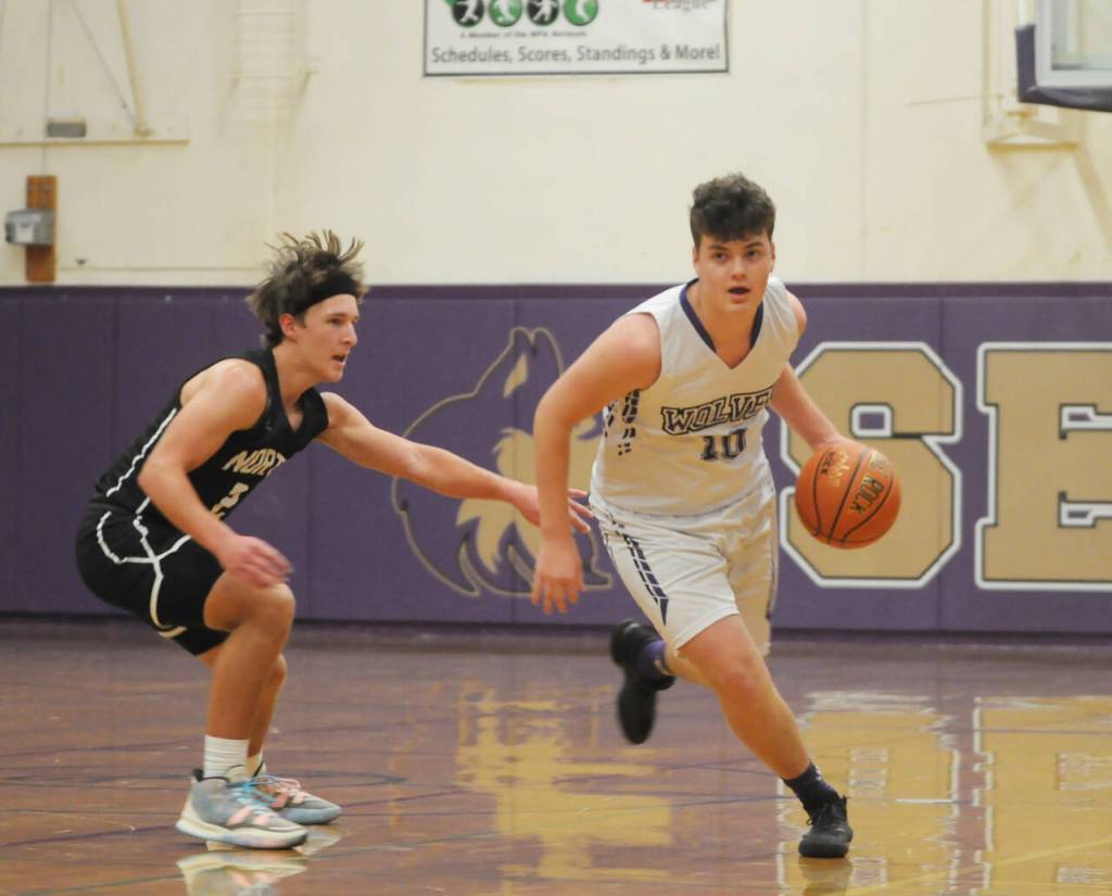 Sequim Gazette photo by Michael Dashiell / Sequims Keenan Green, right drives past North Kitsaps Mason Chmielewski in the Wolves 82-60 loss to the visiting NK Vikings on Dec. 19.