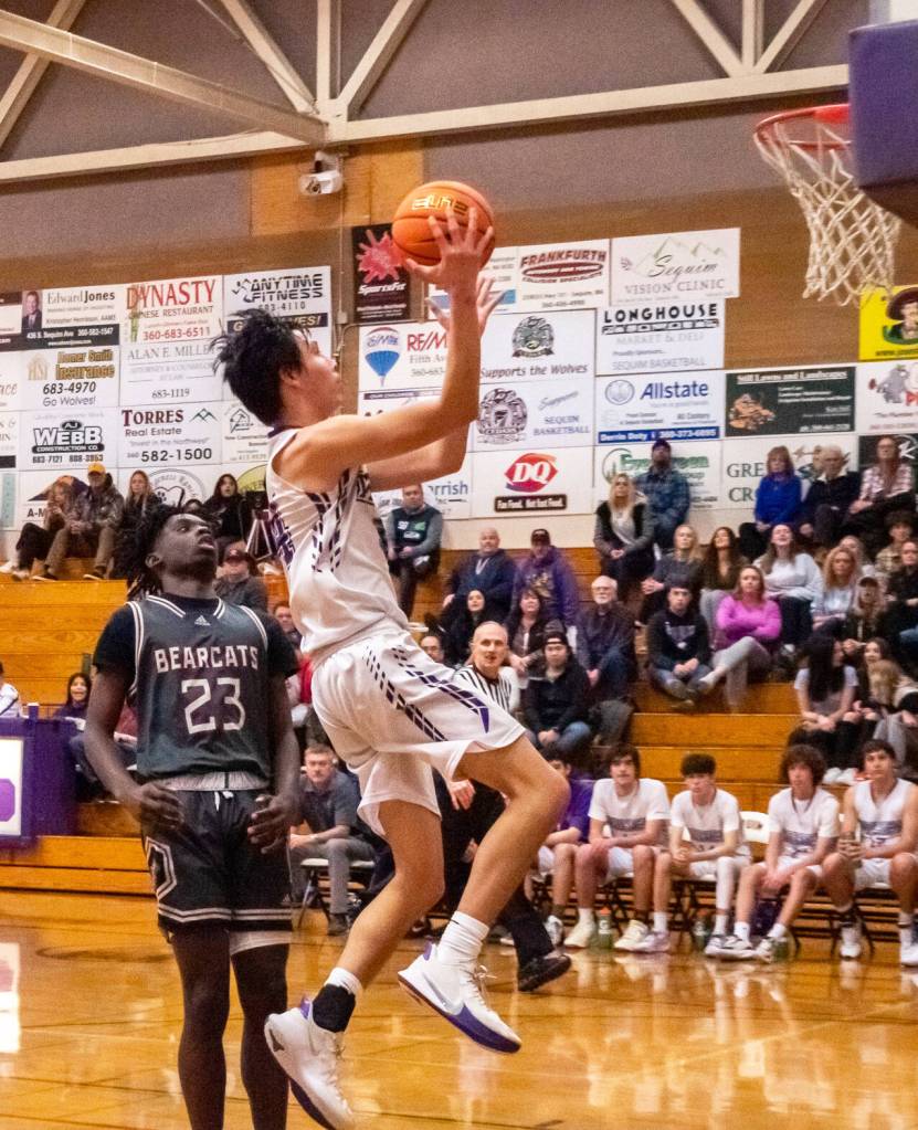 Sequim Gazette photo by Emily Matthiessen / Sequims Isaiah Moore drives past WF Wests Brian Anouma in a Dec. 27 non-league contest in Sequim. WF West won, 60-44.