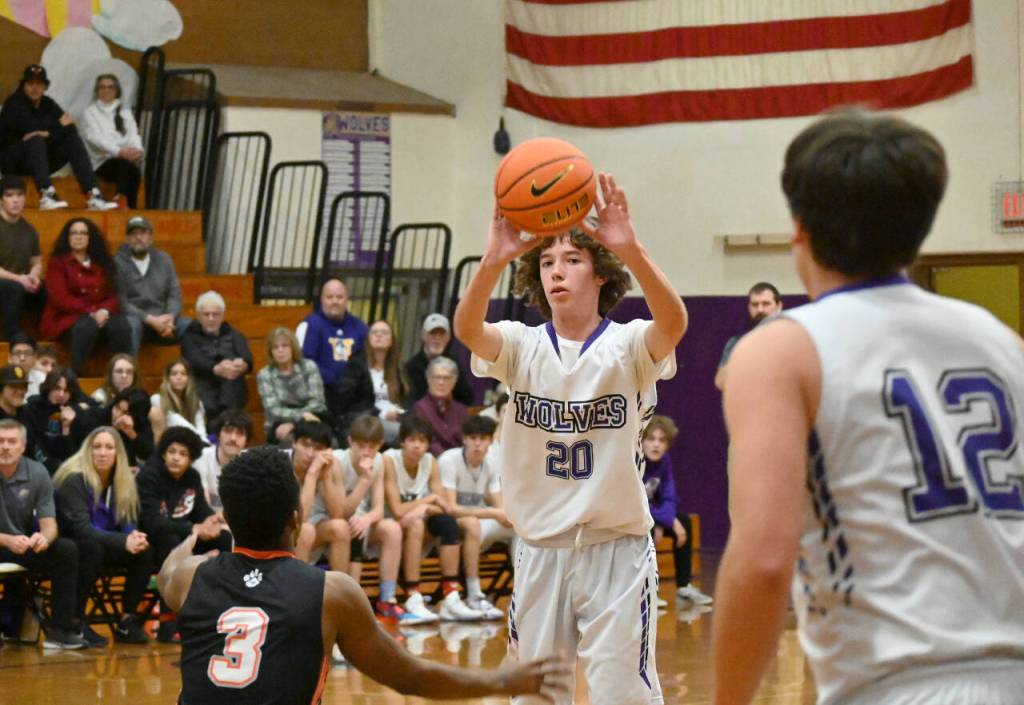 Sequim Gazette photo by Michael Dashiell / Sequims Garrett Little, center, feeds a pass to teammate Espn Judd as Granite Falls Javario Adams guards the play in a Dec. 29 non-league game in Sequim. Sequims Wolves won, 78-43.