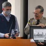 Outgoing Clallam County sheriff Bill Benedict, right, receives parting gifts from Clallam County Commissioner Mark Ozias at a special recognition presentation during a commissioners meeting in Port Angeles on Dec. 27.