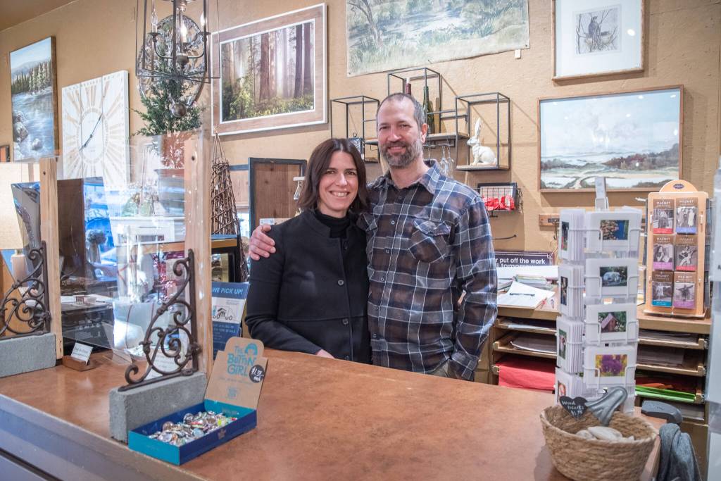 Sequim Gazette photo by Emily Matthiessen / Held by her husband and business partner Scott, Emily Underwood smiles at her parents Jeri and Fran Sanford (not in picture). The Underwoods are the new owners of Over the Fence in Sequim, which they bought from the Sanfords, who plan to visit with friends, travel, garden and have other fun during their retirement, as well as help out at the store occasionally.