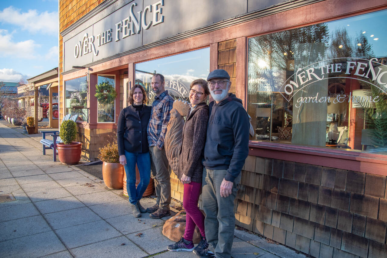 Sequim Gazette photo by Emily Matthiessen /Emily Underwood stands with her husband Scott Underwood, left, and her parents Jeri and Fran Sanford stand on the other side of Over the Fences giant metal rooster. The end of 2022 marks the transition of ownership of the store between the two couples.