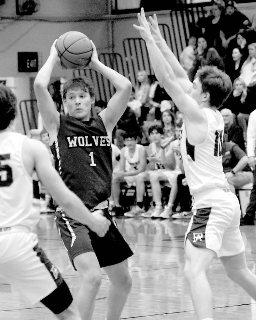 Sequims Zackary Thompson looks for a passing opportinity as Port Angeles Parker Nickerson, left, and Josiah Long close in on Jan. 10 in Port Angeles.