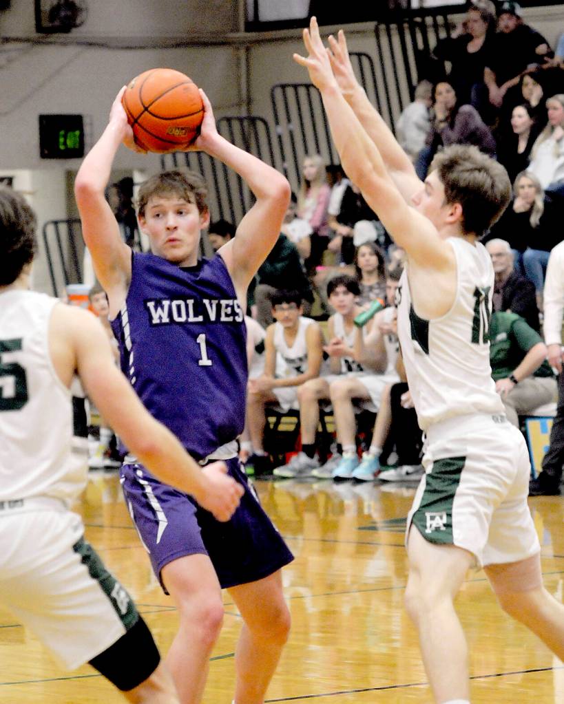 Sequims Zackary Thompson looks for a passing opportinity as Port Angeles Parker Nickerson, left, and Josiah Long close in on Jan. 10 in Port Angeles.