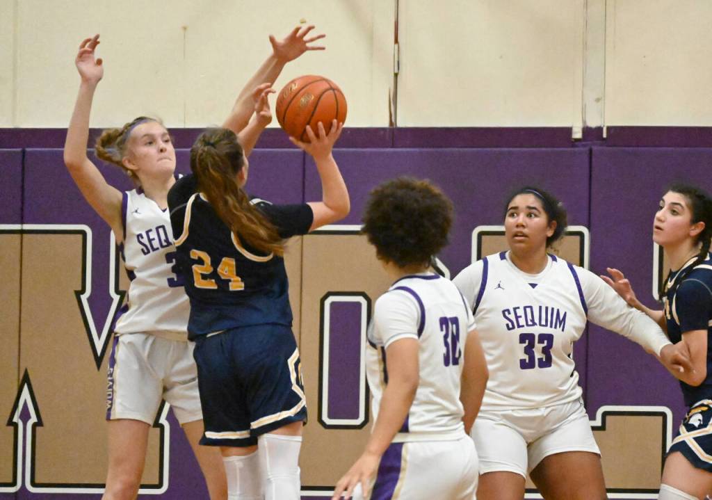 Sequim Gazette photo by Michael Dashiell 
Sequims Jolene Vaara, right, blocks a shot by Bainbridges Bella Ramirez in the fourth quarter of a 38-31 Sequim victory on Jan. 12, as SHS teammates Bobbi Mixon (30) and Jelissa Julmist (33) look on.