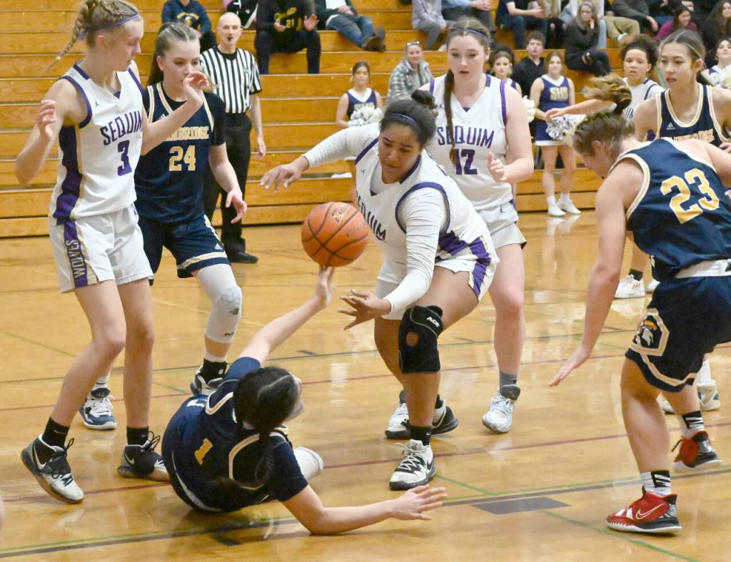 Sequim Gazette photo by Michael Dashiell / Sequim forward Jelissa Julmist, center, steals the ball from Bainbridges Ghadir Ramadan in the fourth quarter of a 38-31 Sequim win on Jan. 12. Looking on are (far left) Sequims Jolene Vaara and Sammie Bacon, and Bainbridges Bella Ramirez (24) and Sierra Berry (23).