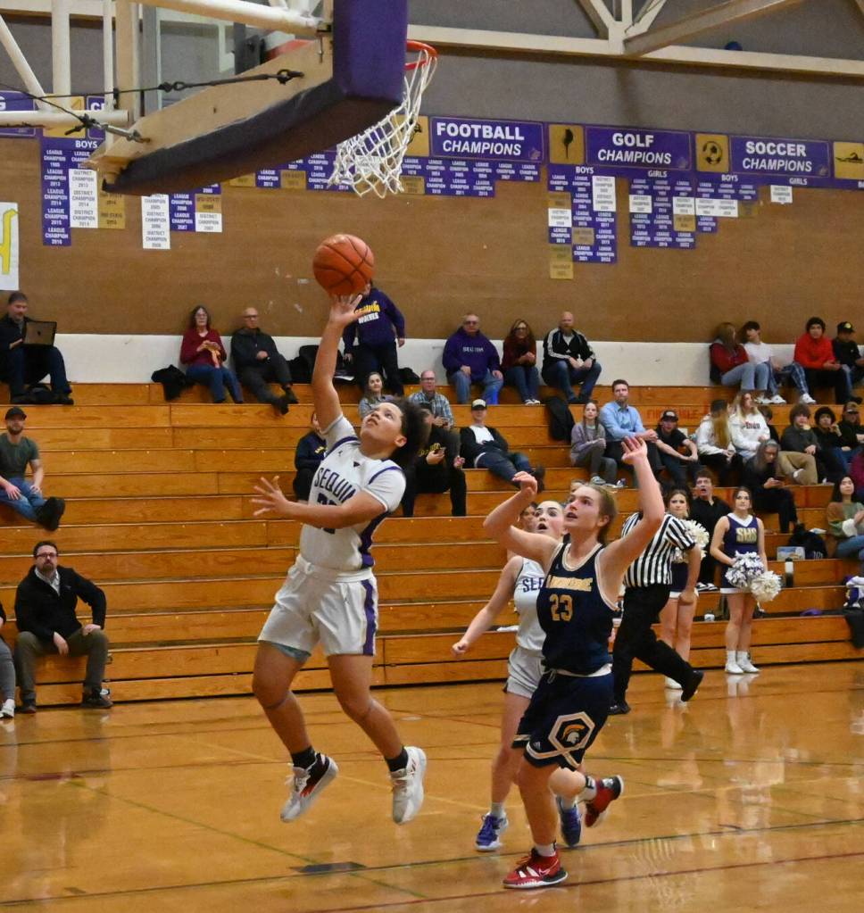 Sequim Gazette photo by Michael Dashiell / Sequims Bobbi Mixon hits a key fourth quarter layup to help seal a 38-31 league win over visiting Bainbridge on Jan. 12. Looking on are Sequims Hannah Bates and Bainbridges Sierra Berry.