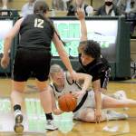 Port Angeles Anna Petty, center, tries to get rid of the ball from the floor as Sequims Sammie Bacon, left, and Bobbie Mixon close in during a key Olympic League matchup in Port Angeles on Jan. 10.