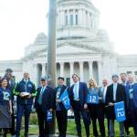 Photo by Reneé Diaz/WNPA News Service / Gov. Jay Inslee, Secretary of State Steve Hobbs and other Washington lawmakers stand in front of the legislative building with Seahawks star Walter Jones after raising the 12th-man flag on Jan. 11.