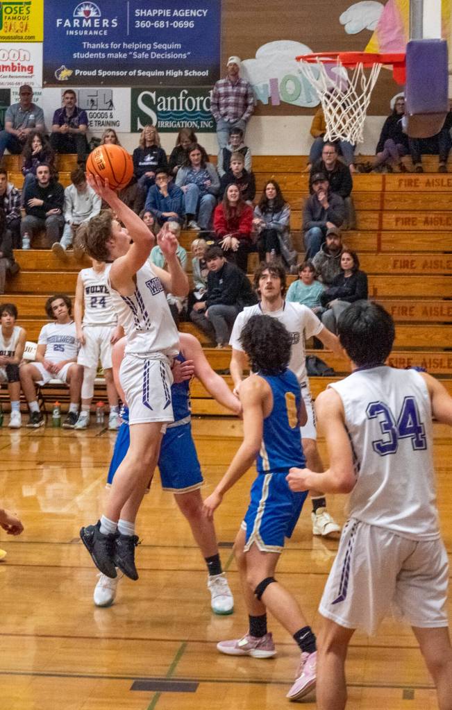 Sequim Gazette photo by Emily Matthiessen / Sequims Zack Thompson looks to score in a Jan. 17 Olympic League home game against Bremerton. Looking on are teammates Cole Smithson (background) and Isaiah Moore (34).