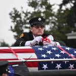 Sequim Gazette photo / Scott Dickson, longtime firefighting partner of Capt. Charles Chad Cate, removes straps securing Cates casket at a memorial Saturday afternoon for the firefighter who was found deceased while on shift on Jan. 12.