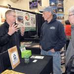 Keith Thorpe/Peninsula Daily News
Will Johnson of Lynnwood-based PermaBilt Post Frame Buildings, left, speaks with Brad and Marla Varner of Sequim at his company's booth at the 22nd annual Building, Remodeling and Energy Expo on Saturday in the gymnasium of Sequim High School. The event, hosted by the North Peninsula Building Association, features a variety of vendors and exhibits covering a wide range of building trades.  The expo continues today from 9 a.m. to 3 p.m. Admission is free.