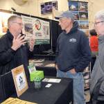 File photo by Keith Thorpe/Olympic Peninsula News Group / Will Johnson of Lynnwood-based PermaBilt Post Frame Buildings, left, speaks with Brad and Marla Varner of Sequim at his companys booth at North Peninsula Building Associations Building, Remodeling and Energy Expo in 2019. NPBA hosts a LEGO building challenge at this years event, set for Feb. 19.