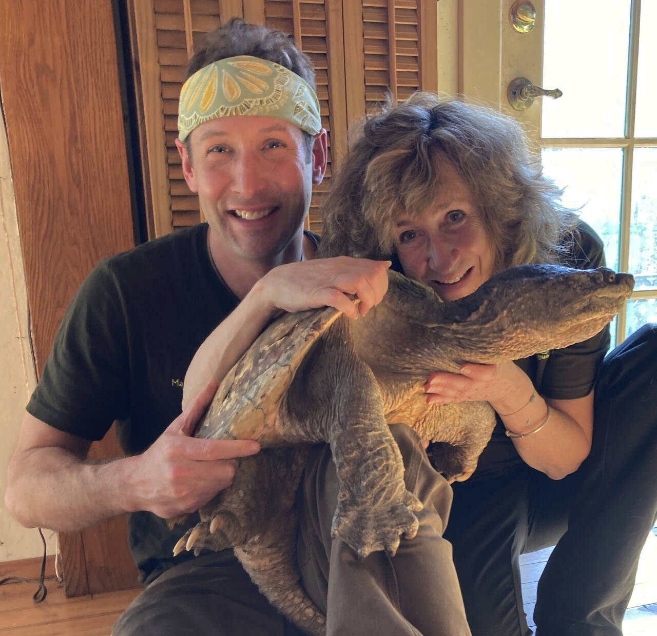 Submitted photo / Fire Chief, a 42-pound wild snapping turtle, is pictured with illustrator Matt Patterson and Sy Montgomery, Peninsula Colleges Spring 2023 Writer in Residence.
